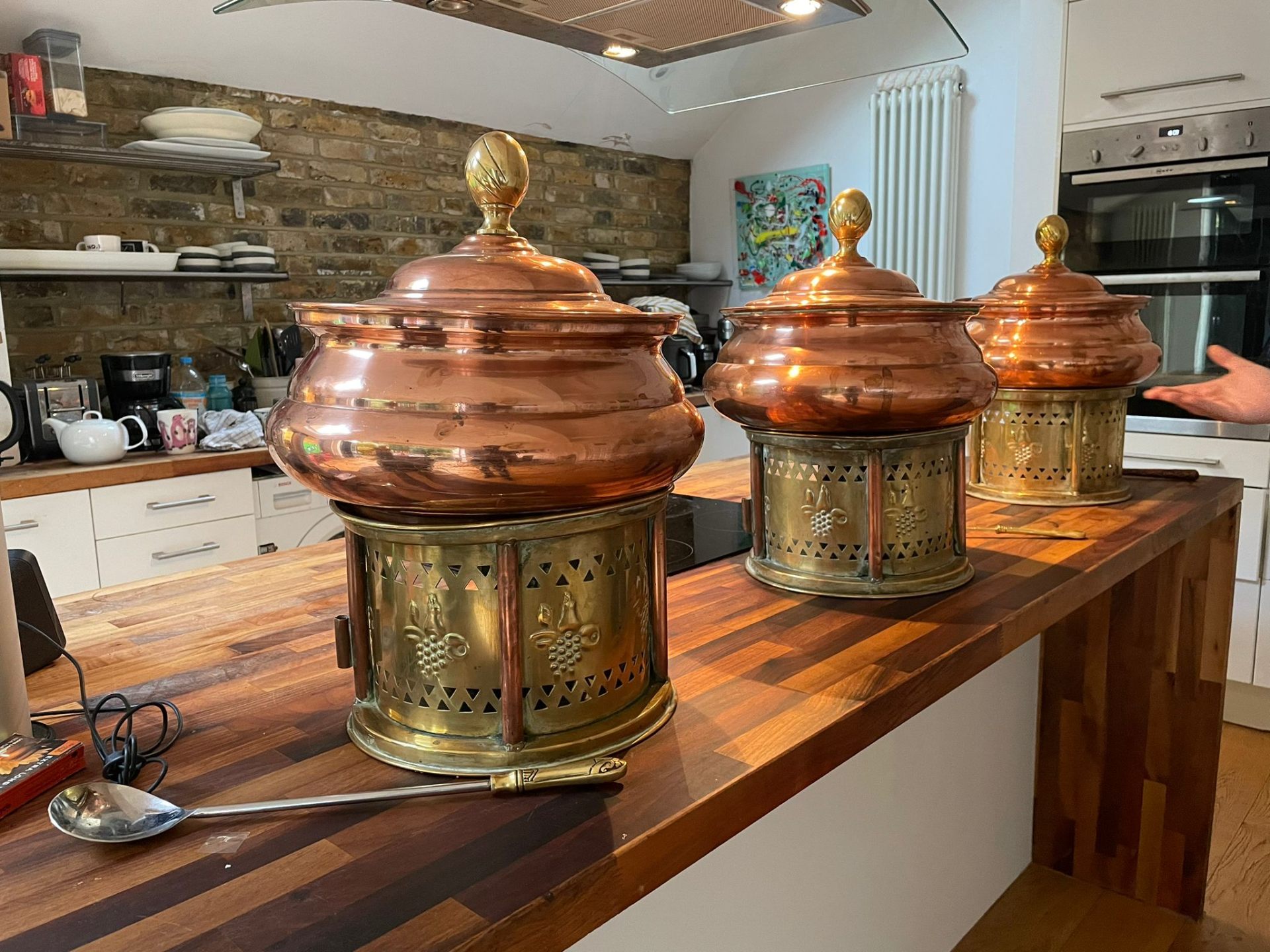Close-up of Jaflong's copper chafing units polished and prepared in the kitchen before an event.