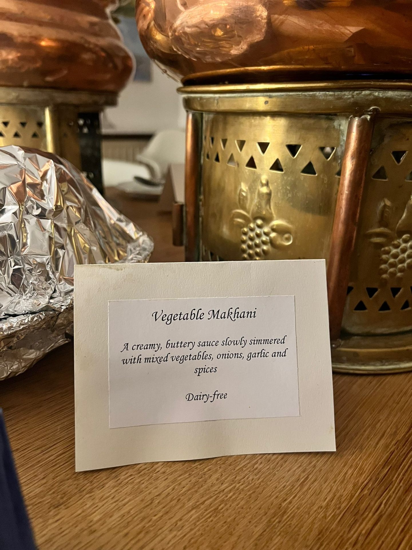 Printed Vegetable Makhani dish card beside a copper chafing unit